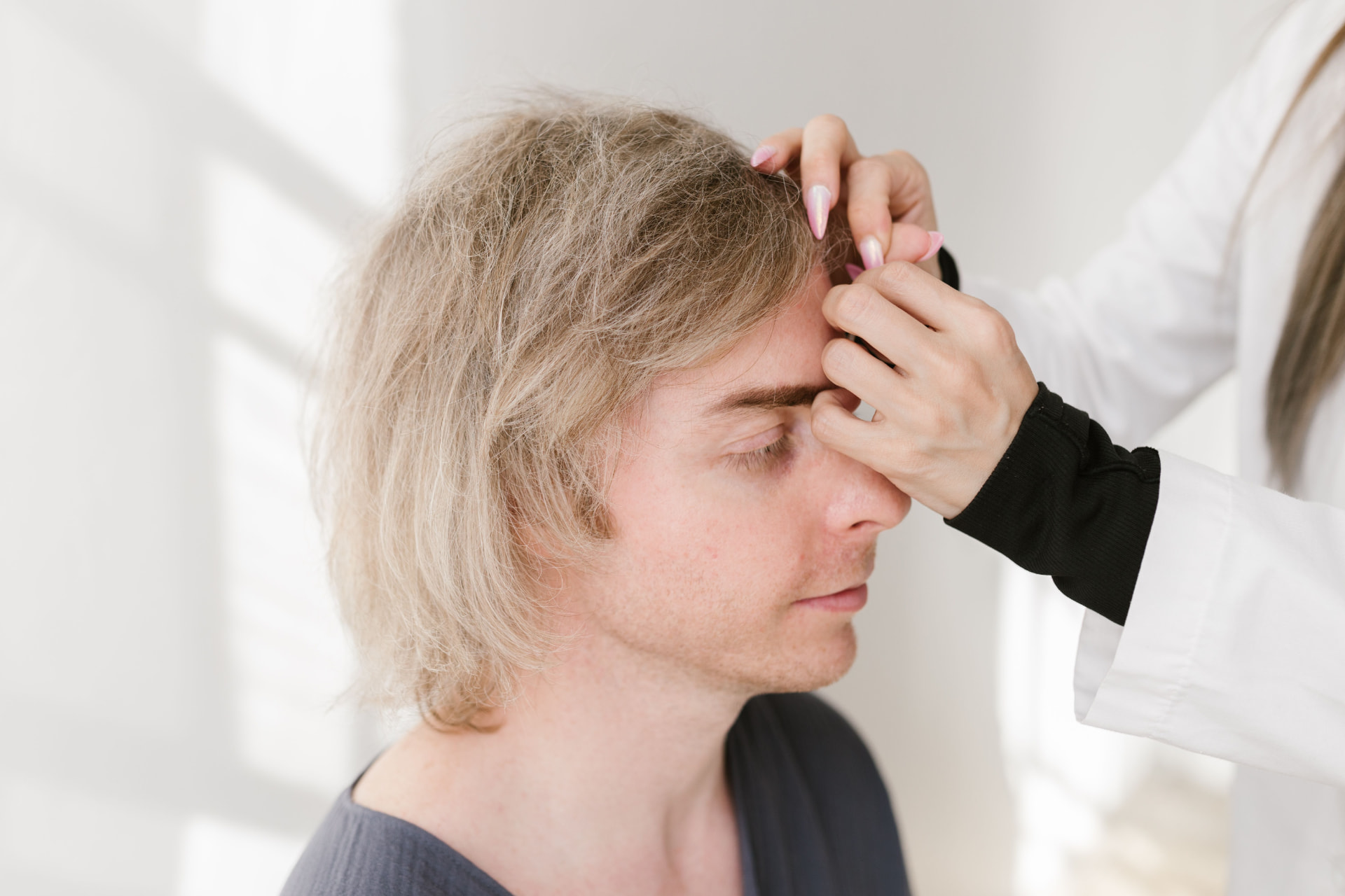 Clinician delivering a gentle scalp treatment in a calm treatment room